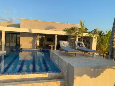 a house with a swimming pool in front of a house at Cabañas Privadas en Playas del Francés con Piscina in San Silvestre