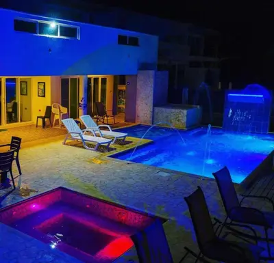 a swimming pool at night with chairs and a table at Cabañas Privadas en Playas del Francés con Piscina in San Silvestre