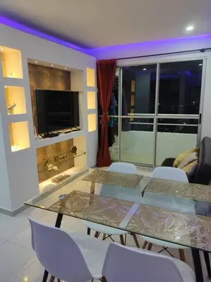 a dining room with a glass table and white chairs at Apto TORRE PRIMI - Cerca al mar in Cartagena de Indias