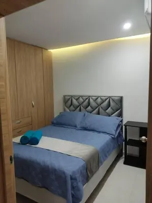 a bedroom with a large bed with blue pillows at Apto TORRE PRIMI - Cerca al mar in Cartagena de Indias