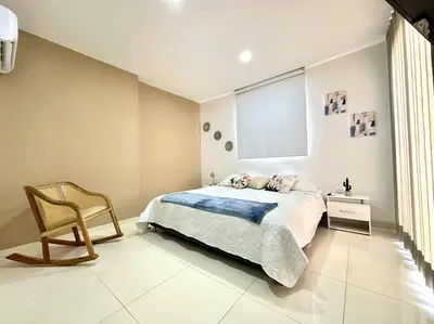 a bedroom with a bed and a chair and a window at Moderno e Iluminado Apartamento in Sincelejo