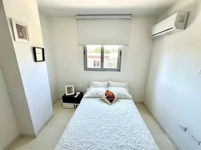 a small white room with a bed with a window at Moderno e Iluminado Apartamento in Sincelejo