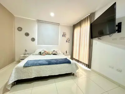 a bedroom with a large bed and a flat screen tv at Moderno e Iluminado Apartamento in Sincelejo