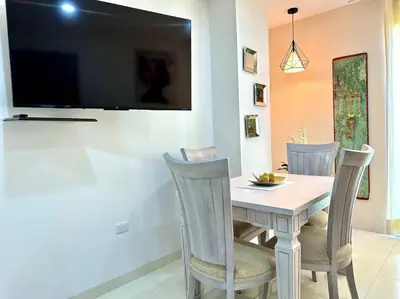 a dining room table with two chairs and a television on a wall at Moderno e Iluminado Apartamento in Sincelejo