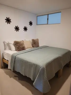 a bedroom with a large bed with pillows and a window at Apartamento cerca al Mar in Cartagena de Indias
