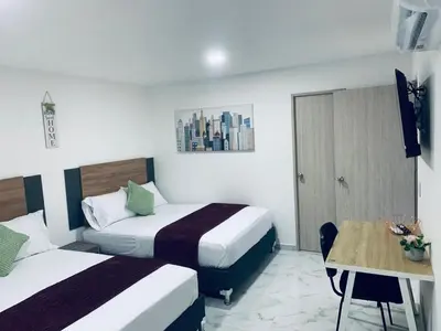 a hotel room with two beds and a table at Apartamento Lindo en cartagena el laguito bocagrande con vista al mar in Cartagena de Indias