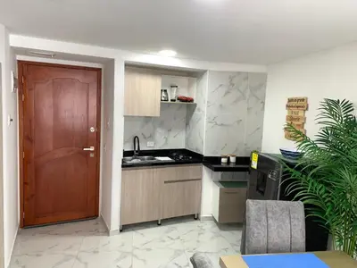 a kitchen with a wooden door and a counter top at Apartamento Lindo en cartagena el laguito bocagrande con vista al mar in Cartagena de Indias
