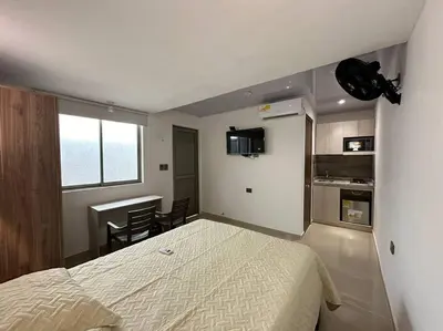 a small bedroom with a bed and a kitchen at Apartaestudio 1 en Barranquilla in Barranquilla