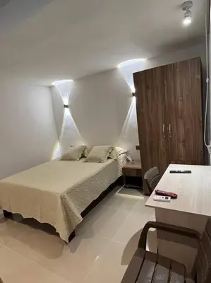 a bedroom with a bed and a table with a chair at Apartaestudio 1 en Barranquilla in Barranquilla