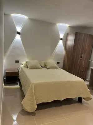 a bedroom with a bed with two lights on the wall at Apartaestudio 1 en Barranquilla in Barranquilla