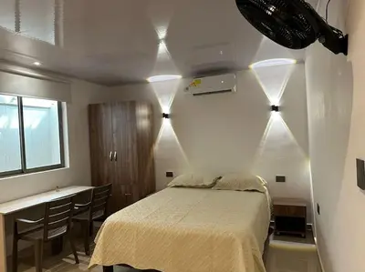 a bedroom with a bed and a desk with chairs at Apartaestudio 2 en Barranquilla in Barranquilla