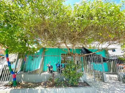 a fence with a tree in front of a building at Apartamento Doña Flor in Coveñas