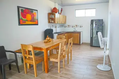 a kitchen and dining room with a wooden table and chairs at Apartamento Doña Flor in Coveñas