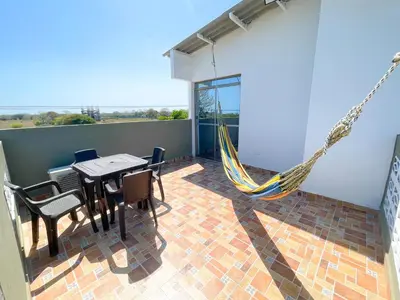 a patio with a hammock and a table and chairs at Apartamento Doña Flor in Coveñas