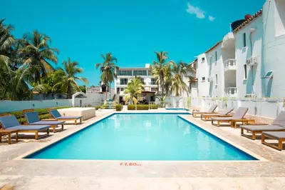 a swimming pool with lounge chairs and a resort at Hotel Caribe Coveñas in Coveñas