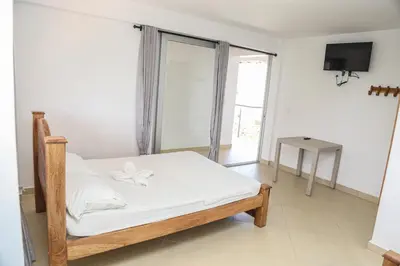 a bedroom with a bed with white sheets and a window at Hotel Caribe Coveñas in Coveñas