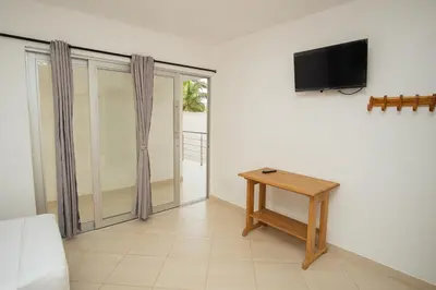 a room with a table and a tv on a wall at Hotel Caribe Coveñas in Coveñas