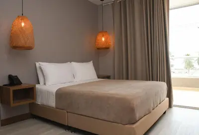 a bedroom with a bed with two lamps and a window at Ciela Hotel in Coveñas