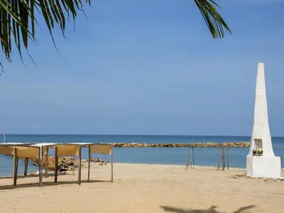 a table and chairs on the beach with a lighthouse at Ciela Hotel in Coveñas