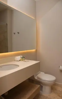 a bathroom with a sink and a toilet and a mirror at Ciela Hotel in Coveñas