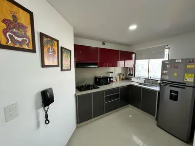 a kitchen with red cabinets and a stainless steel refrigerator at Apartamento en Edificio Portofino 606 ICDI in Cartagena de Indias