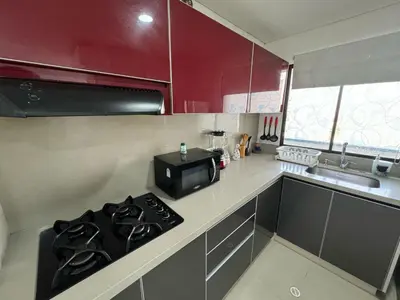 a kitchen with red cabinets and a stove top oven at Apartamento en Edificio Portofino 606 ICDI in Cartagena de Indias