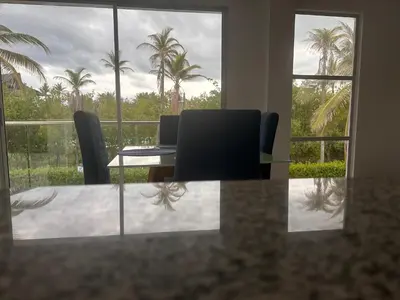 a dining room with a table and chairs and palm trees at Casa 5 Brisa Piso 2- Palmar De Los Vientos in San Bernardo del Viento