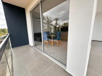 a balcony with sliding glass doors with a table and chairs at Casa 5 Brisa Piso 2- Palmar De Los Vientos in San Bernardo del Viento