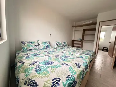 a bedroom with a bed with a blue and white comforter at Casa 5 Brisa Piso 2- Palmar De Los Vientos in San Bernardo del Viento