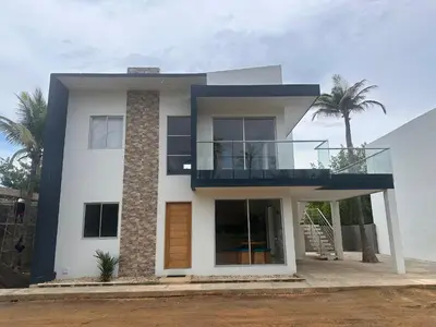 a white house with a balcony and palm trees at Casa 5 Brisa Piso 2- Palmar De Los Vientos in San Bernardo del Viento