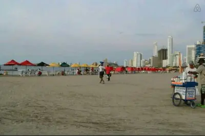 a cart on a beach with people and buildings at Apartamento en Cartagena, cerca al mar, edificio Nuevo Conquistador in Cartagena de Indias