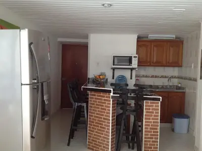 a kitchen with a counter with a microwave and a refrigerator at Apartamento en Cartagena, cerca al mar, edificio Nuevo Conquistador in Cartagena de Indias