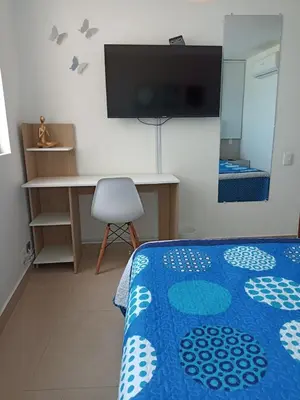 a bedroom with a bed and a desk and a tv at Apartamento ideal frente al mar con vista espectacular in Cartagena de Indias