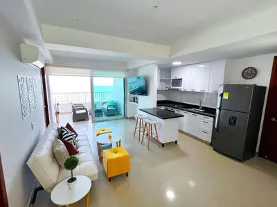 a living room with a couch and a kitchen at Apartamento ideal frente al mar con vista espectacular in Cartagena de Indias