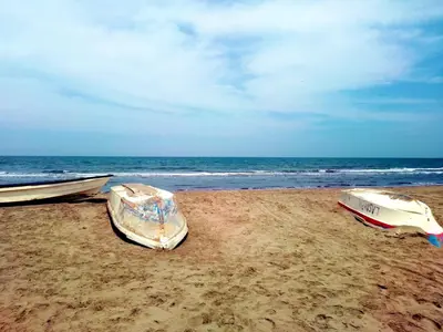 three boats sitting on the sand on the beach at Casa MAR de FE in Cartagena de Indias