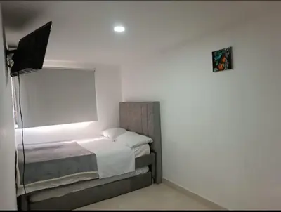 a bedroom with a bed in a white room at Hermoso apartamento in Cartagena de Indias