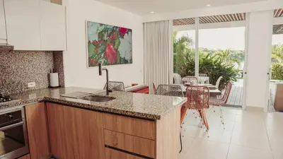 a kitchen with a counter and a dining room with a table at Villa Karibana Paradise in Cartagena de Indias