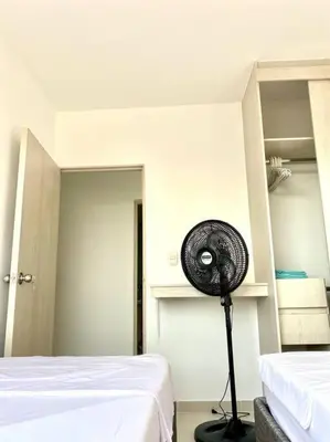a room with a fan next to two beds at Apartamento en Cartagena in Cartagena de Indias