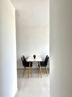 a dining room with a white table and black chairs at Apartamento en Cartagena in Cartagena de Indias