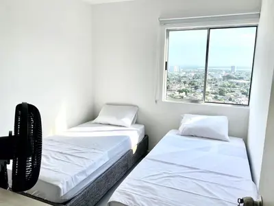 two beds in a small room with a window at Apartamento en Cartagena in Cartagena de Indias