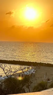 a group of people on a beach at sunset at Espectacular Ocean view, apartamento de dos cuartos, con vista al mar, en Cartagena de Indias in Cartagena de Indias