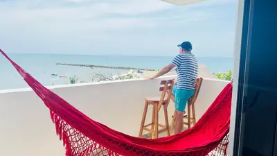 a man standing on a balcony looking out at the ocean at Espectacular Ocean view, apartamento de dos cuartos, con vista al mar, en Cartagena de Indias in Cartagena de Indias