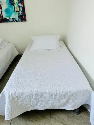 a white bed with a white comforter on it at Espectacular Ocean view, apartamento de dos cuartos, con vista al mar, en Cartagena de Indias in Cartagena de Indias