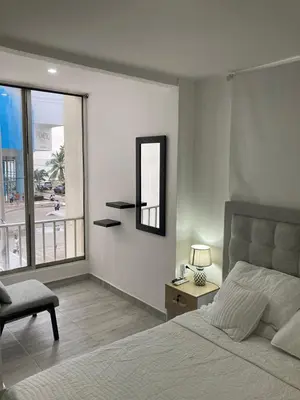 a bedroom with a bed and a mirror and a chair at Amazing Ocean View apartment with Pool in Laguito Cartagena in Cartagena de Indias