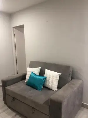 a brown couch with two blue and white pillows at Amazing Ocean View apartment with Pool in Laguito Cartagena in Cartagena de Indias