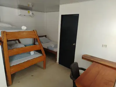 a small room with a bunk bed and a desk at Hotel Palmetto Beach Coveñas in Coveñas