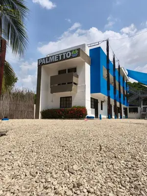 a building in the middle of a gravel road at Hotel Palmetto Beach Coveñas in Coveñas