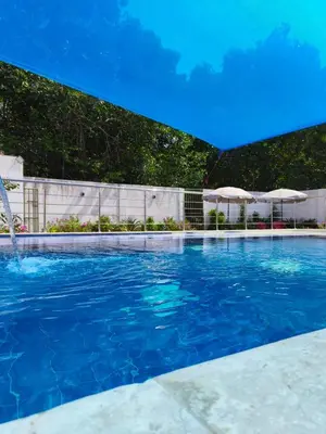 a swimming pool with blue water and umbrellas at Hotel Palmetto Beach Coveñas in Coveñas