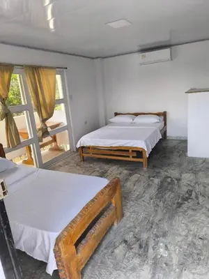 a bedroom with two beds and a window at Hotel Palmetto Beach Coveñas in Coveñas
