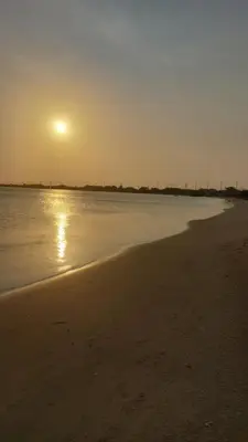 a beach with the sun setting over the water at Puerta al Mar Ecolodge Glamping in Tubará